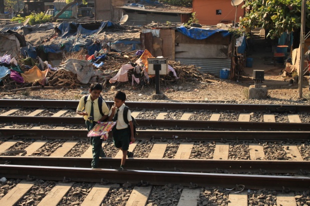 šolarja iz slumov v šolski uniformi s kravato. živijo le par metrov stran od železniških tirov. predstavljam si, da se obrneš v spanju in te povozi vlak